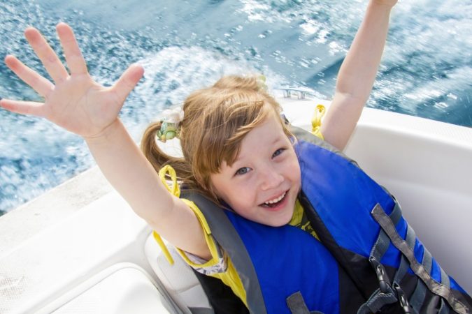 child with life jacket in a boat